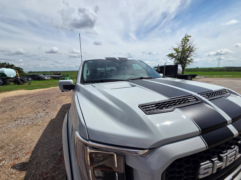 Silver Ford Shelby F-150 hood detailed to a mirror shine on the farm